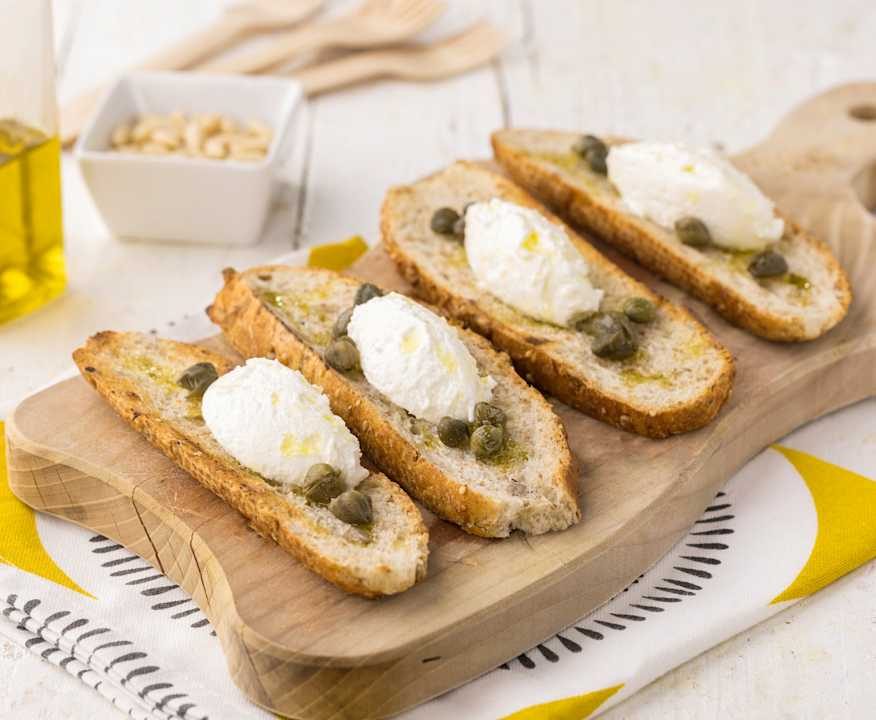 Crostini di pane integrale con crema al caprino, capperi e pinoli Protein